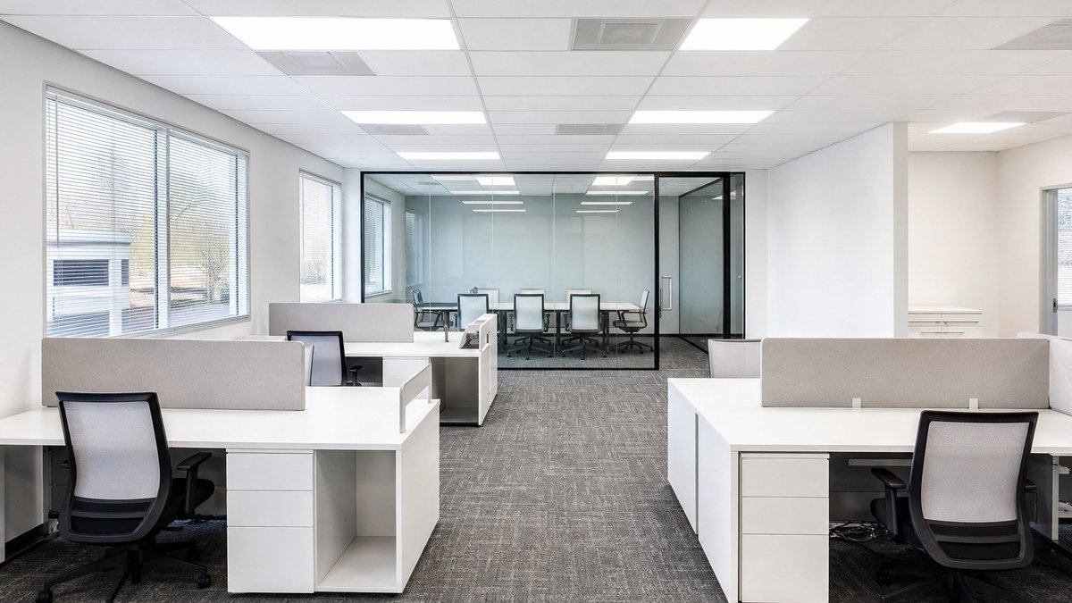 Bright open-plan interior of a modular office building with workstations and a glass-walled conference room